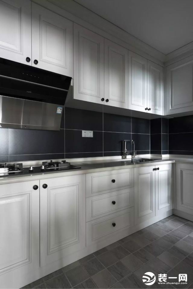厨房以灰色地砖基础,在白色橱柜的后方是黑色的墙面砖,整体显得销代